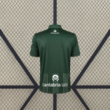 Vista trasera de la camiseta Racing Santander 26-27 visitante en verde oscuro con ribetes dorados y detalle de líneas verticales en la zona inferior