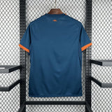 Vista trasera de la camiseta Valencia 26-27 visitante en azul oscuro, con puños naranjas y pequeño detalle naranja bajo el cuello