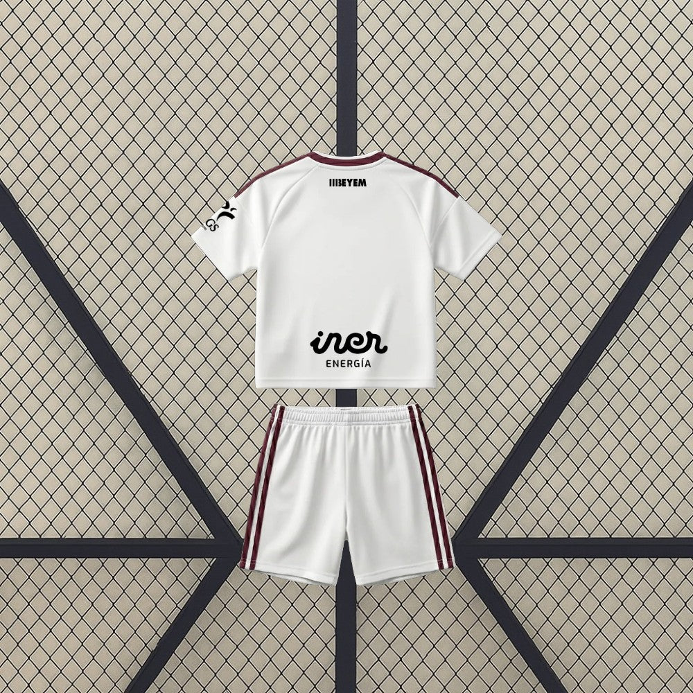 Vista trasera de la equipación Albacete 26-27 Local de niño con camiseta y pantalón blancos y franjas laterales granates
