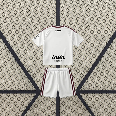 Vista trasera de la equipación Albacete 26-27 Local de niño con camiseta y pantalón blancos y franjas laterales granates