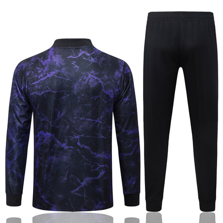 Vista trasera del chándal Barcelona 26-27 Modelo 1 con chaqueta de manga larga con estampado morado y pantalón negro a juego