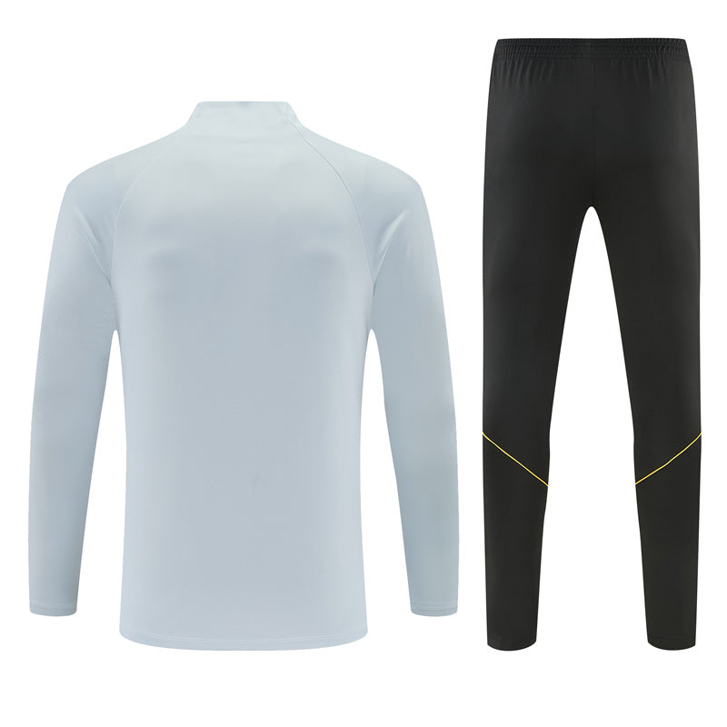 Vista trasera del chándal Barcelona 26-27 Modelo 1 con parte superior azul claro y pantalón negro de cintura elástica