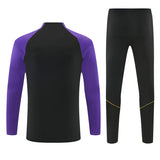 Vista trasera del chándal Barcelona 26-27 Modelo 2 con parte superior negra de mangas moradas y pantalón negro