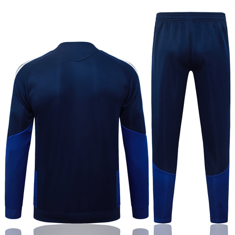 Vista trasera del chándal Boca Juniors 26-27 Modelo 2 con chaqueta azul marino lisa y pantalón azul marino con paneles azules en la parte inferior