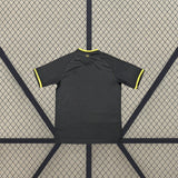 Vista trasera de la camiseta Jordania 26-27 tercera equipación en color oscuro con detalles amarillos