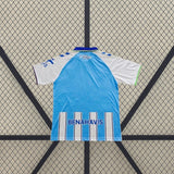 Camiseta Málaga 26-27 local vista trasera en azul celeste con detalles blancos