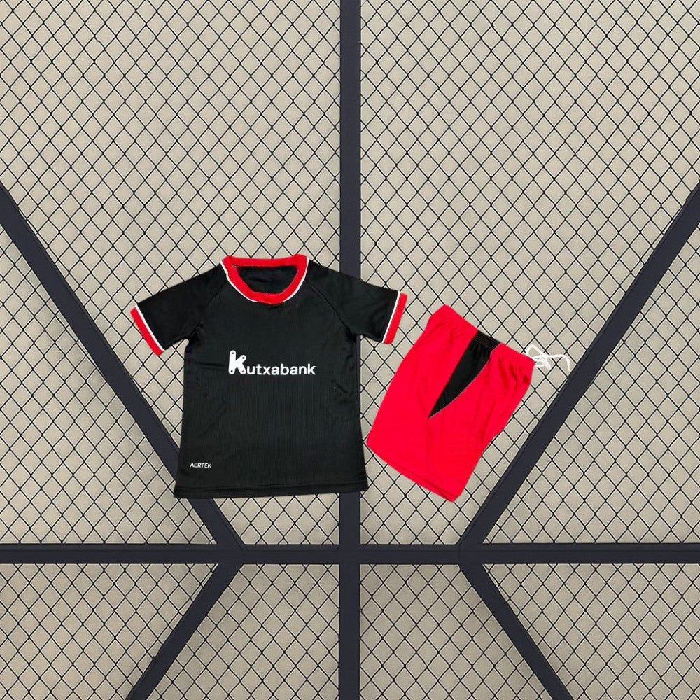 Equipación Athletic de Bilbao 26-27 visitante niño frontal con camiseta negra y pantalón rojo